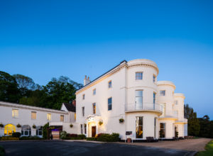 Front exterior shot of Mercure Gloucester Bowden Hall hotel at dusk
