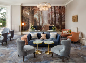 Chairs and sofas in the lounge looking over a large picture at Mercure Gloucester Bowden Hall Hotel