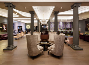 The grand lobby with tables and chairs and bar at Mercure Leicester The Grand Hotel