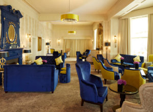 Blue and yellow chairs and tables in the lounge area at Mercure Newbury Elcot Park Hotel
